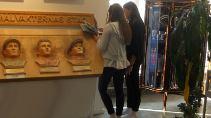 Elever från en skola i Hyllinge läser bildhistorien om träskulpturerna.